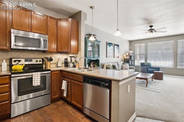 4219 Mesa Point, Colorado Springs, CO 80923 - kitchen featuring appliances with stainless steel finishes, a sink, open floor plan, a peninsula, and brown cabinetry