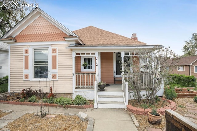 712 W Cucharras St, Colorado Springs, CO 80905 - view of front of home featuring a chimney, a porch, and roof with shingles
