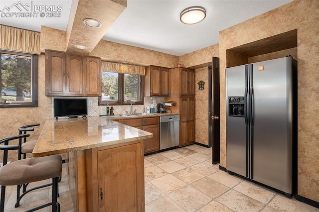 2518 Avondale Dr, Colorado Springs, CO 80917 - kitchen featuring stainless steel appliances, a peninsula, a sink, and brown cabinetry