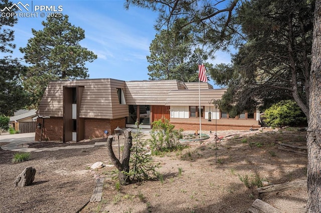 2518 Avondale Dr, Colorado Springs, CO 80917 - back of house featuring brick siding and mansard roof