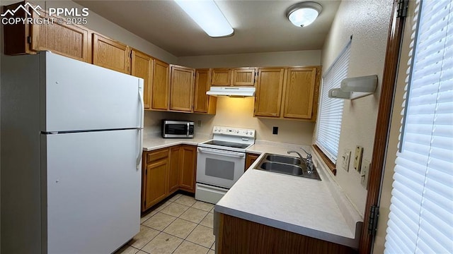 5185 Balsam St, Colorado Springs, CO 80923 - kitchen with white appliances, under cabinet range hood, a sink, light tile patterned floors, and light countertops