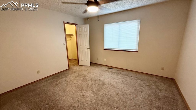 5185 Balsam St, Colorado Springs, CO 80923 - unfurnished bedroom featuring carpet floors, a textured ceiling, baseboards, a walk in closet, and a ceiling fan
