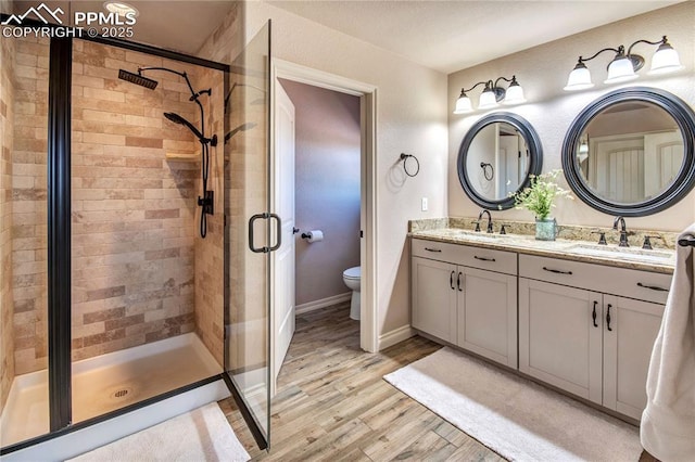 6728 Gelbvieh Rd, Peyton, CO 80831 - full bathroom with a stall shower, wood finished floors, and double vanity
