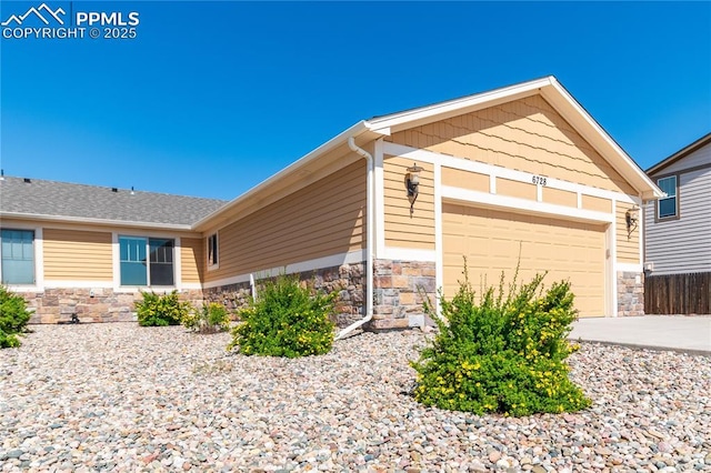 6728 Gelbvieh Rd, Peyton, CO 80831 - view of side of home featuring stone siding, a garage, and driveway