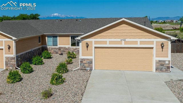 6728 Gelbvieh Rd, Peyton, CO 80831 - craftsman house featuring stone siding, concrete driveway, a mountain view, and an attached garage