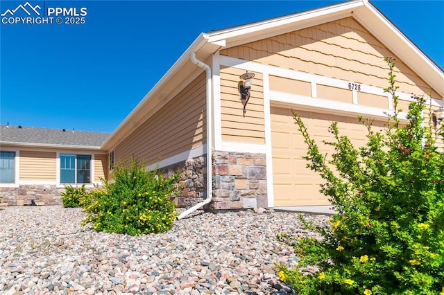 6728 Gelbvieh Rd, Peyton, CO 80831 - view of property exterior with stone siding and an attached garage