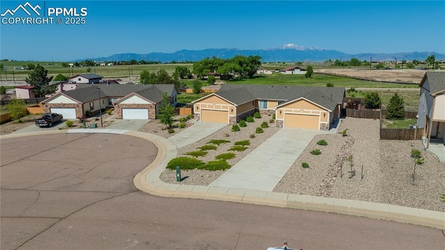 6728 Gelbvieh Rd, Peyton, CO 80831 - view of front facade with a mountain view, concrete driveway, and a garage