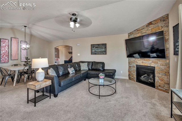 6728 Gelbvieh Rd, Peyton, CO 80831 - carpeted living room featuring vaulted ceiling, a ceiling fan, arched walkways, and a fireplace
