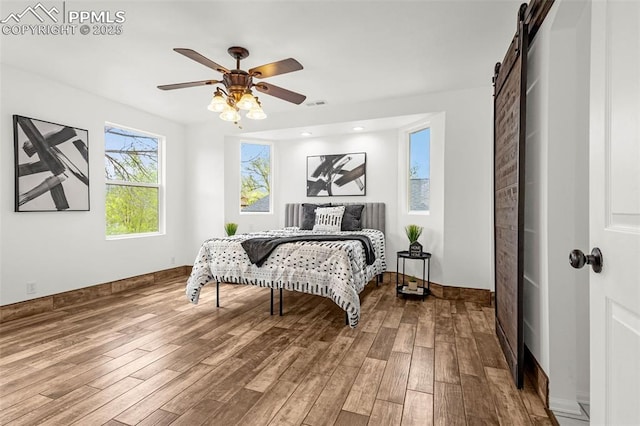 321 Graceland Grv, Colorado Springs, CO 80904 - bedroom featuring wood finished floors, a barn door, a ceiling fan, and baseboards