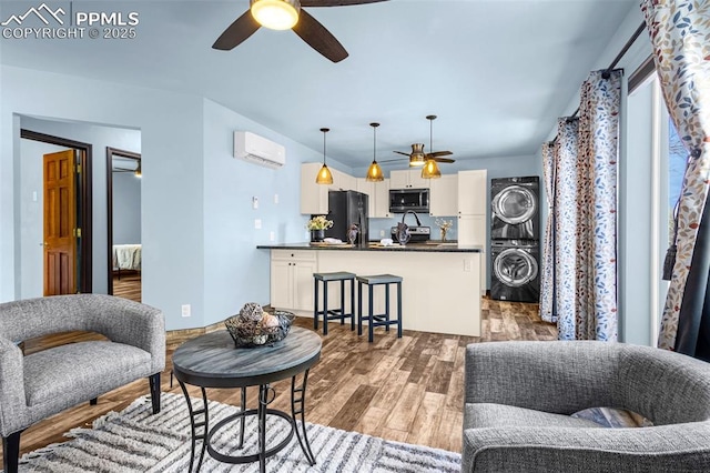 321 Graceland Grv, Colorado Springs, CO 80904 - living room featuring stacked washer / drying machine, ceiling fan, wood finished floors, and a wall mounted air conditioner