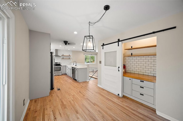 1515 W Boulder St, Colorado Springs, CO 80904 - kitchen featuring open shelves, appliances with stainless steel finishes, a barn door, decorative backsplash, and recessed lighting