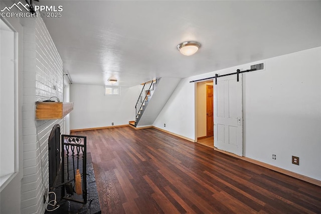 1515 W Boulder St, Colorado Springs, CO 80904 - unfurnished living room featuring wood finished floors, baseboards, stairs, a barn door, and a fireplace