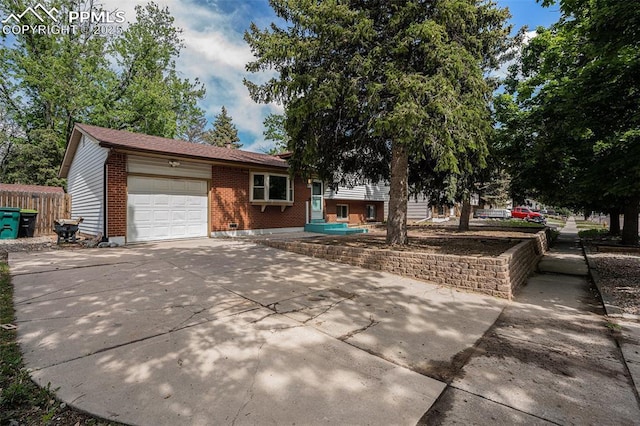 1125 Moffat Cir, Colorado Springs, CO 80915 - tri-level home with brick siding, a garage, and driveway