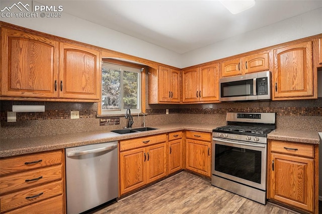 1125 Moffat Cir, Colorado Springs, CO 80915 - kitchen featuring appliances with stainless steel finishes, a sink, tasteful backsplash, and brown cabinetry