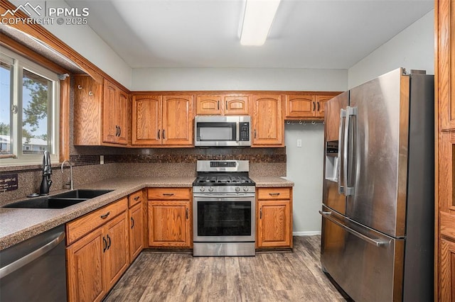 1125 Moffat Cir, Colorado Springs, CO 80915 - kitchen with stainless steel appliances, a sink, dark wood-style flooring, and backsplash