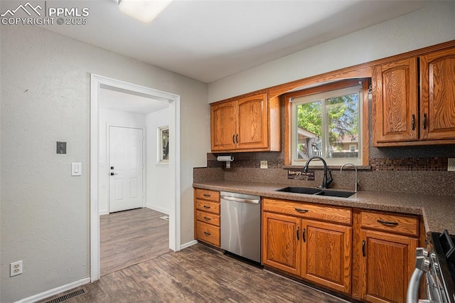 1125 Moffat Cir, Colorado Springs, CO 80915 - kitchen with appliances with stainless steel finishes, a sink, backsplash, dark wood finished floors, and brown cabinetry