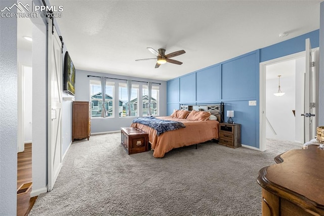 10597 Luneth Dr, Colorado Springs, CO 80925 - carpeted bedroom featuring ceiling fan and a barn door