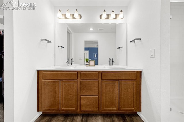 10597 Luneth Dr, Colorado Springs, CO 80925 - full bathroom with double vanity, wood finished floors, a shower, and a spacious closet