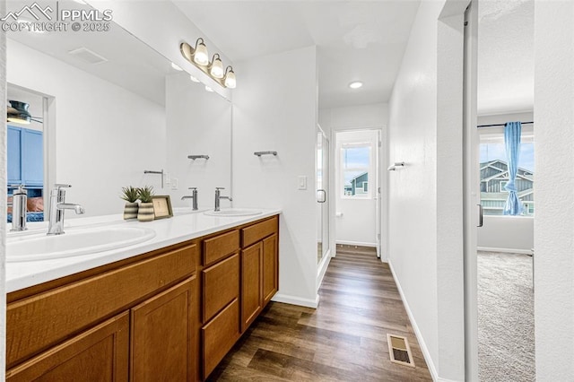 10597 Luneth Dr, Colorado Springs, CO 80925 - full bath featuring double vanity, wood finished floors, and baseboards