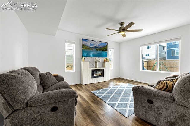 10597 Luneth Dr, Colorado Springs, CO 80925 - living room featuring wood finished floors, a ceiling fan, baseboards, and a glass covered fireplace