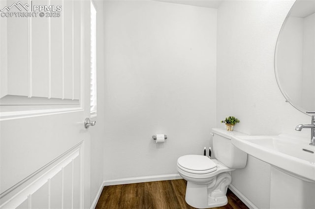 10597 Luneth Dr, Colorado Springs, CO 80925 - half bath with wood finished floors, toilet, and baseboards