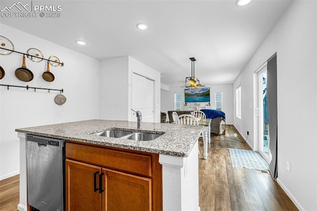 10597 Luneth Dr, Colorado Springs, CO 80925 - kitchen featuring stainless steel dishwasher, a sink, wood finished floors, brown cabinetry, and recessed lighting