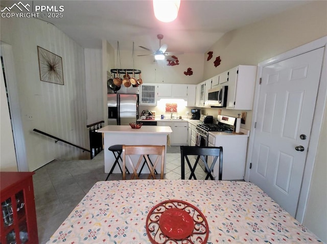 2115 Rangeview Dr, Pueblo, CO 81008 - kitchen with stainless steel appliances, white cabinets, a ceiling fan, a center island, and light countertops