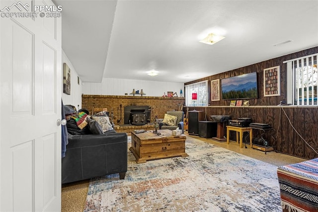 2115 Rangeview Dr, Pueblo, CO 81008 - living room featuring wooden walls, healthy amount of natural light, and a wood stove
