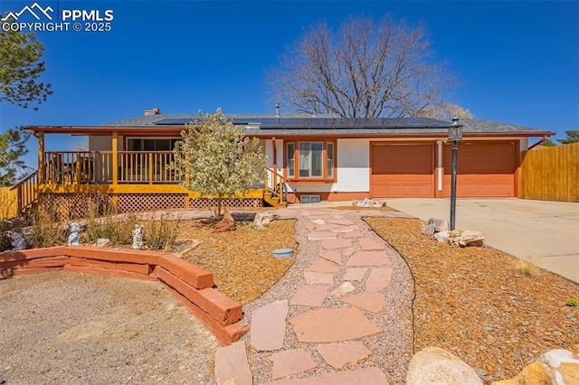 2115 Rangeview Dr, Pueblo, CO 81008 - view of front of house featuring driveway, roof mounted solar panels, a garage, and a porch