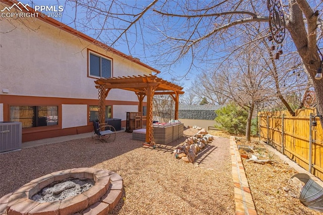 2115 Rangeview Dr, Pueblo, CO 81008 - fenced backyard featuring an outdoor living space with a fire pit, central AC, a pergola, and a patio area
