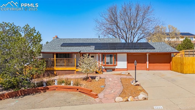 2115 Rangeview Dr, Pueblo, CO 81008 - view of front of property with roof mounted solar panels, a shingled roof, a chimney, and concrete driveway