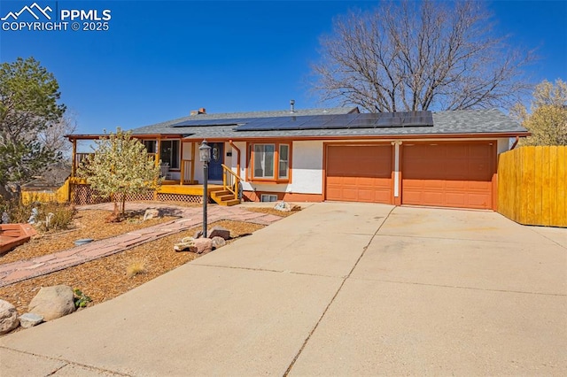 2115 Rangeview Dr, Pueblo, CO 81008 - view of front of house with an attached garage, roof mounted solar panels, concrete driveway, and roof with shingles