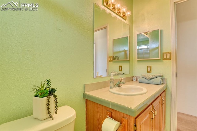 20040 Drennan Rd, Colorado Springs, CO 80928 - bathroom featuring vanity, toilet, and a textured wall