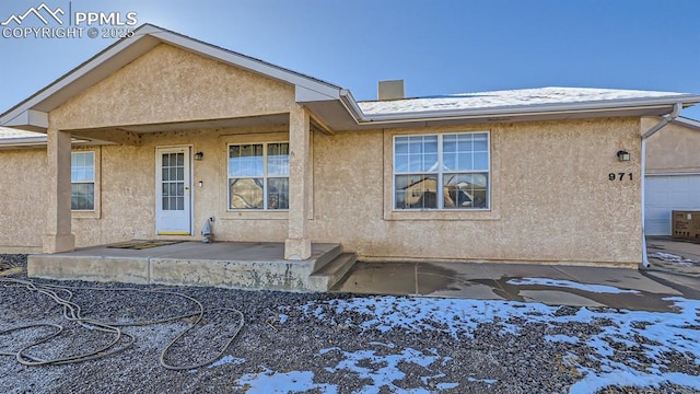 971 S Los Charros Dr, Pueblo West, CO 81007 - snow covered rear of property featuring stucco siding and a porch