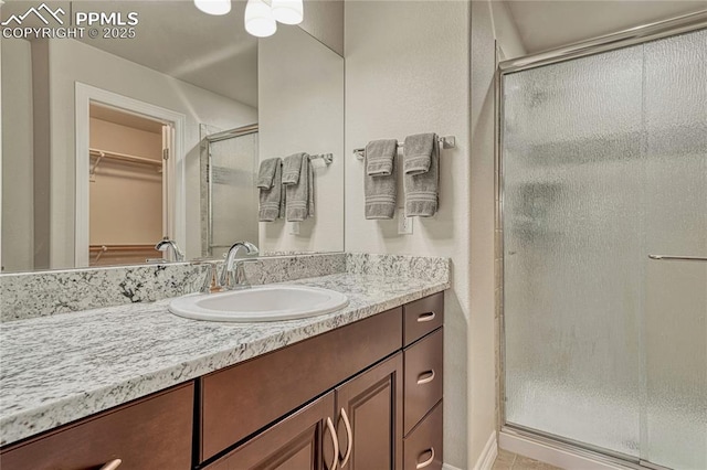 14745 Millhaven Pl, Colorado Springs, CO 80908 - full bath with a shower stall, vanity, and a walk in closet