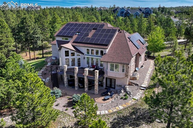 14745 Millhaven Pl, Colorado Springs, CO 80908 - rear view of house with stairs, a shingled roof, a deck, a patio, and solar panels