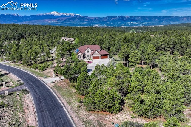14745 Millhaven Pl, Colorado Springs, CO 80908 - drone / aerial view of a heavily wooded area and a mountainous background