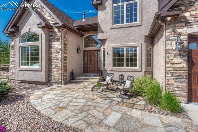 14745 Millhaven Pl, Colorado Springs, CO 80908 - doorway to property with stone siding and stucco siding