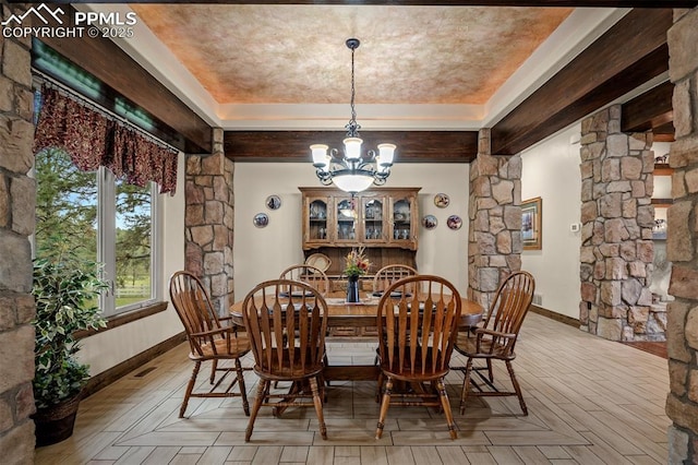 8610 Wildridge Rd, Colorado Springs, CO 80908 - dining area featuring a chandelier, ornate columns, a tray ceiling, and baseboards