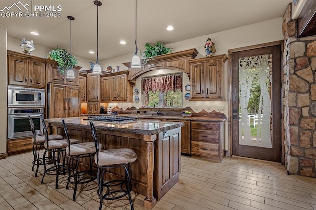8610 Wildridge Rd, Colorado Springs, CO 80908 - kitchen with appliances with stainless steel finishes, a sink, light wood-type flooring, a kitchen island, and recessed lighting