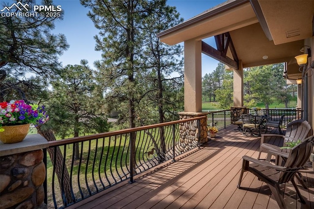 8610 Wildridge Rd, Colorado Springs, CO 80908 - deck with outdoor dining space and view of wooded area