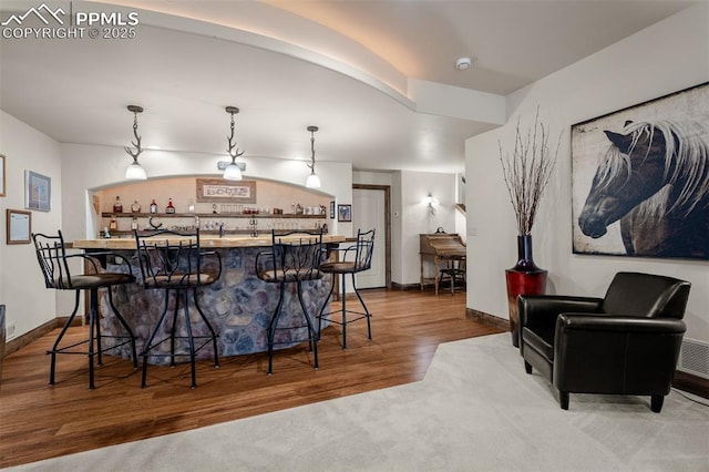 8610 Wildridge Rd, Colorado Springs, CO 80908 - kitchen featuring a kitchen breakfast bar, pendant lighting, wood finished floors, and baseboards