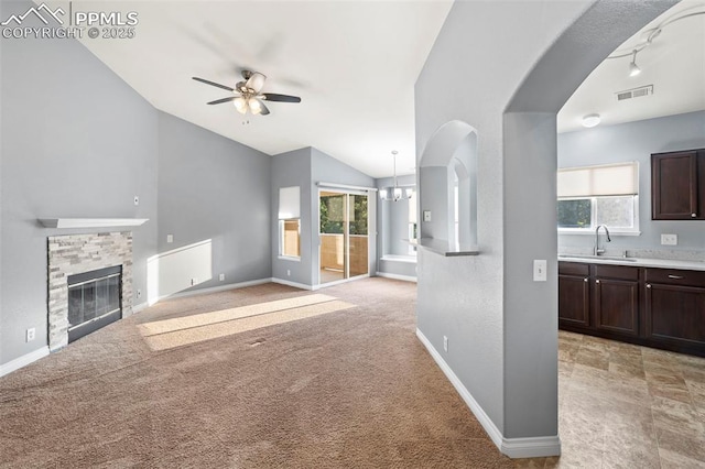 3730 Penny Pt Unit G, Colorado Springs, CO 80906 - unfurnished living room featuring a sink, vaulted ceiling, ceiling fan, plenty of natural light, and a stone fireplace