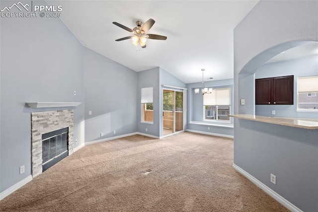 3730 Penny Pt Unit G, Colorado Springs, CO 80906 - unfurnished living room featuring vaulted ceiling, ceiling fan, a chandelier, a glass covered fireplace, and light carpet