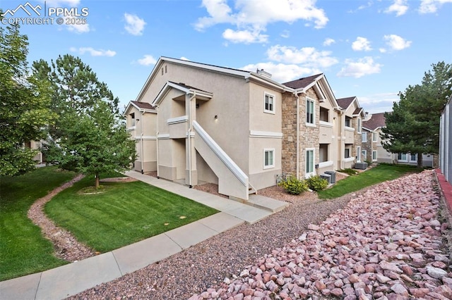 3730 Penny Pt Unit G, Colorado Springs, CO 80906 - view of side of property featuring stucco siding, a residential view, a yard, and stone siding