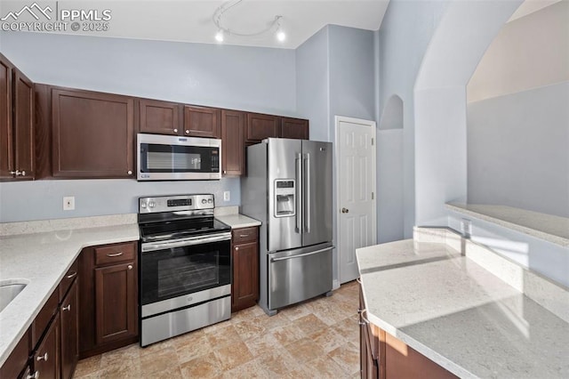 3730 Penny Pt Unit G, Colorado Springs, CO 80906 - kitchen featuring appliances with stainless steel finishes, dark brown cabinetry, and light stone counters