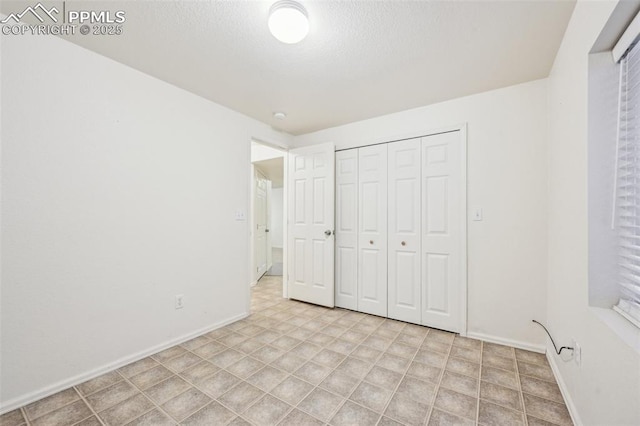 7619 Steward Ln, Colorado Springs, CO 80922 - unfurnished bedroom featuring baseboards, a closet, and a textured ceiling