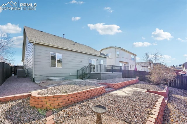 7619 Steward Ln, Colorado Springs, CO 80922 - back of property featuring a fenced backyard, central air condition unit, a patio area, a deck, and a shingled roof