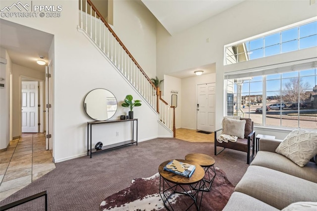 7619 Steward Ln, Colorado Springs, CO 80922 - living area featuring stairs, a towering ceiling, carpet, plenty of natural light, and baseboards