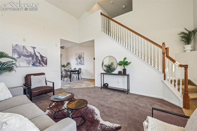 7619 Steward Ln, Colorado Springs, CO 80922 - carpeted living area featuring stairway, high vaulted ceiling, and baseboards